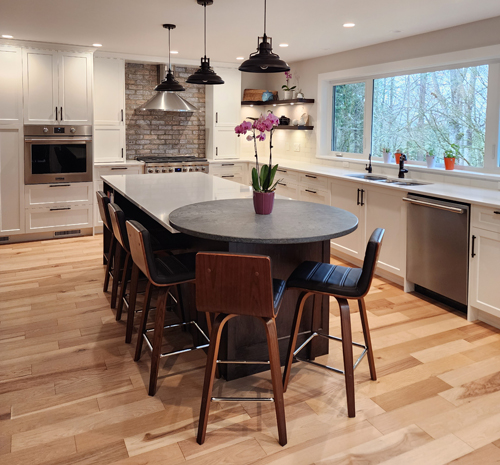 langley-1 A spacious kitchen with a central island and polished wooden floors, designed for functionality and style.