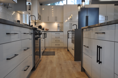 langley-2 Bright kitchen with extensive white cabinetry and a stylish black stove as the focal point.